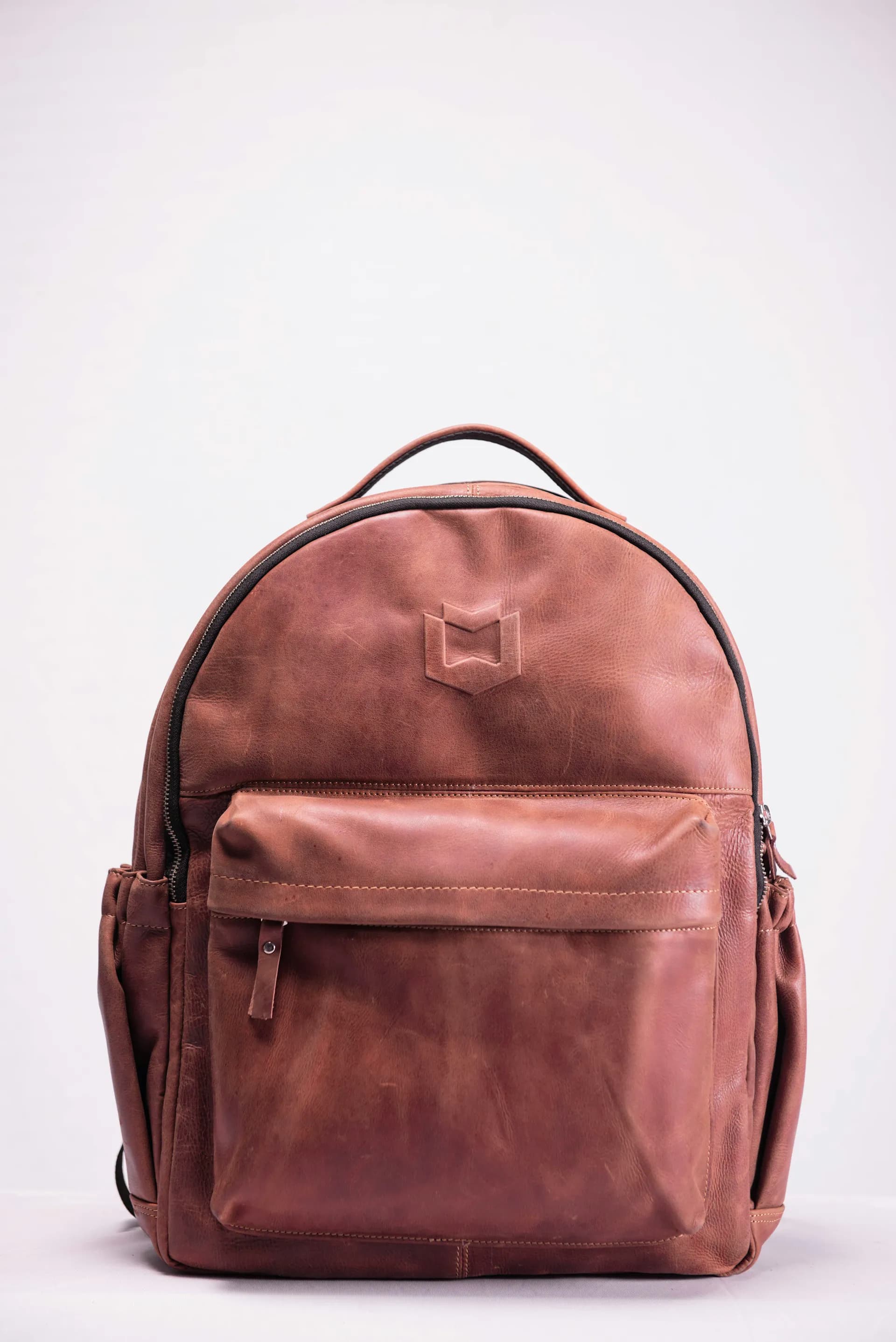 Original product photo of a brown leather backpack on a plain white background